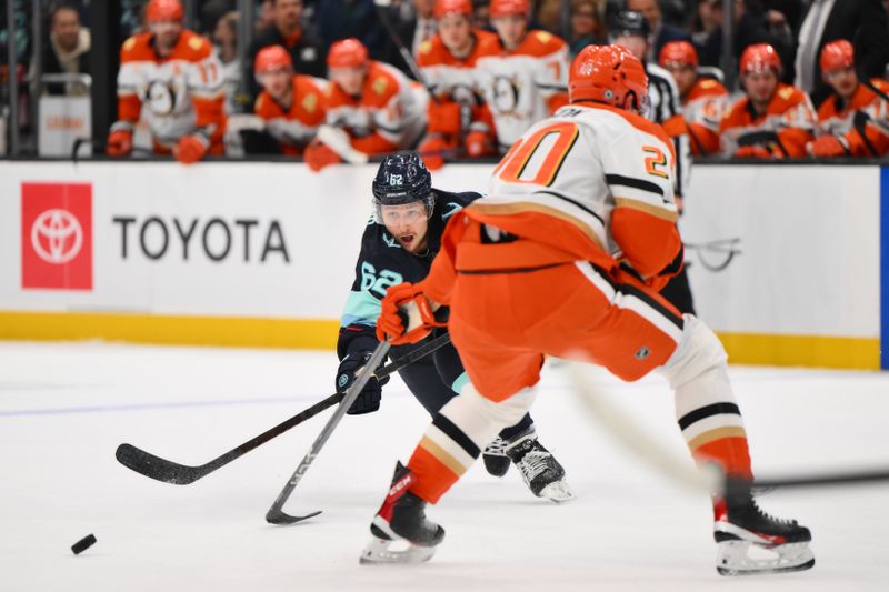 Nov 27, 2024; Seattle, Washington, USA; Seattle Kraken defenseman Brandon Montour (62) passes the puck past Anaheim Ducks right wing Brett Leason (20) during the third period at Climate Pledge Arena. Mandatory Credit: Steven Bisig-Imagn Images