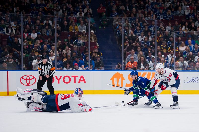 Mar 16, 2024; Vancouver, British Columbia, CAN; Washington Capitals forward Tom Wilson (43) watches as goalie Charlie Lindgren (79) poke checks Vancouver Canucks forward Conor Garland (8) in the first period at Rogers Arena. Mandatory Credit: Bob Frid-USA TODAY Sports