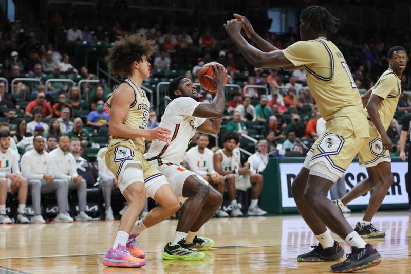 Feb 24, 2024; Coral Gables, Florida, USA; Miami Hurricanes guard Bensley Joseph (4) fakes a shot against Georgia Tech Yellow Jackets guard Naithan George (2) and forward Baye Ndongo (11) during the second half at Watsco Center. Mandatory Credit: Sam Navarro-USA TODAY Sports