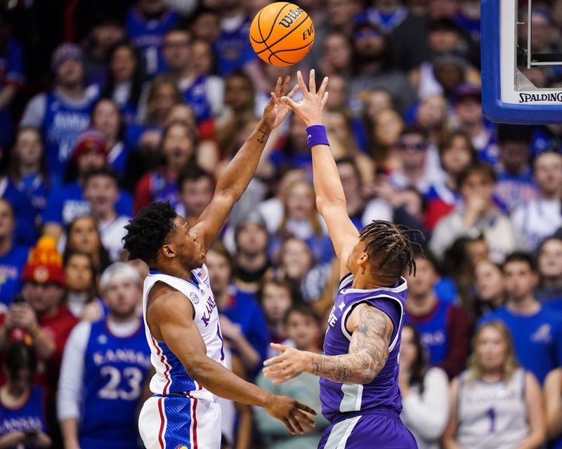 Jan 31, 2023; Lawrence, Kansas, USA; Kansas Jayhawks guard Joseph Yesufu (1) shoots against Kansas State Wildcats forward Keyontae Johnson (11) during the first half at Allen Fieldhouse. Mandatory Credit: Jay Biggerstaff-USA TODAY Sports