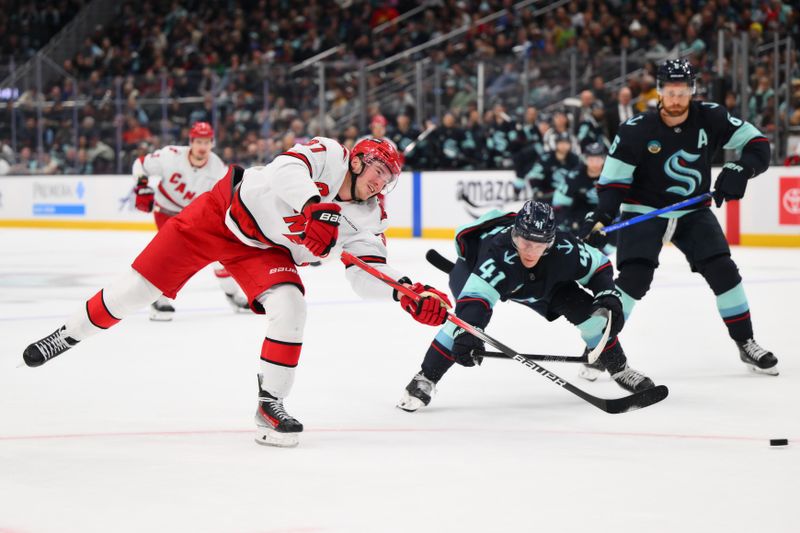 Oct 26, 2024; Seattle, Washington, USA; Carolina Hurricanes right wing Andrei Svechnikov (37) shoots the puck while defended by Seattle Kraken defenseman Ryker Evans (41) during the second period at Climate Pledge Arena. Mandatory Credit: Steven Bisig-Imagn Images