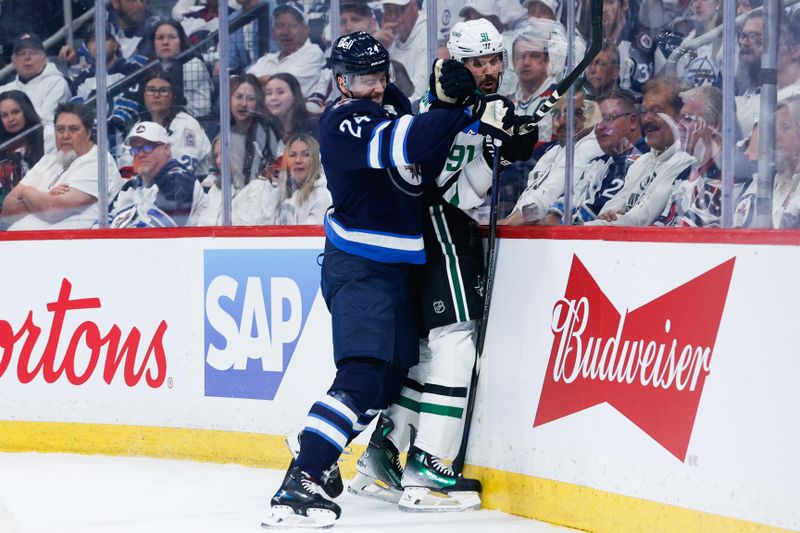 May 7, 2025; Winnipeg, Manitoba, CAN; Winnipeg Jets defenseman Hayden Fleury (24) bodies Dallas Stars forward Tyler Seguin (91) during the first period in game one of the second round of the 2025 Stanley Cup Playoffs at Canada Life Centre. Mandatory Credit: Terrence Lee-Imagn Images