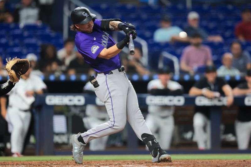 Jun 3, 2025; Miami, Florida, USA; Colorado Rockies left fielder Jordan Beck (27) hits an RBI single against the Miami Marlins during the fifth inning at loanDepot Park. Mandatory Credit: Sam Navarro-Imagn Images
