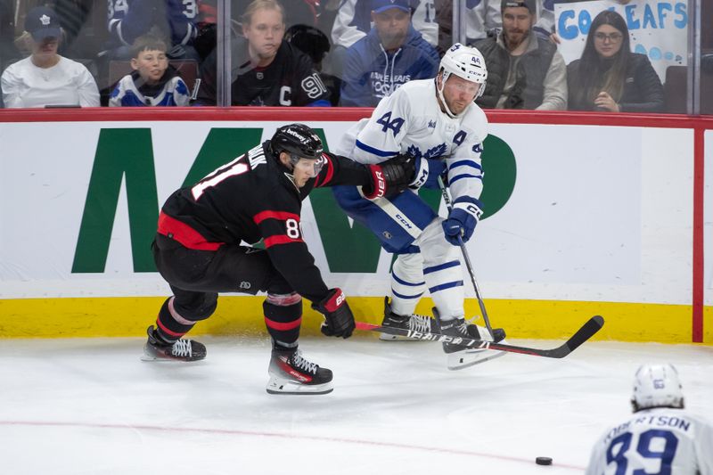 Feb 10, 2024; Ottawa, Ontario, CAN; Toronto Maple Leafs defenseman Morgan Rielly (44) moves the puck away from Ottawa Senators left wing Dominik Kubalik (81) in the third period at the Canadian Tire Centre. Mandatory Credit: Marc DesRosiers-USA TODAY Sports