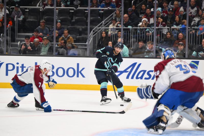 Dec 16, 2025; Seattle, Washington, USA; Seattle Kraken center Matty Beniers (10) passes the puck while defended by Colorado Avalanche defenseman Devon Toews (7) during the second period at Climate Pledge Arena. Mandatory Credit: Steven Bisig-Imagn Images