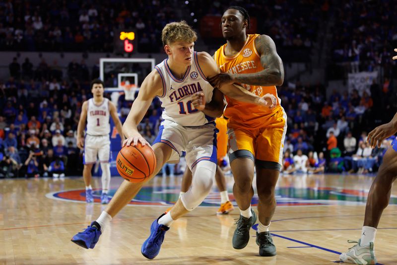 Jan 7, 2025; Gainesville, Florida, USA; Florida Gators forward Thomas Haugh (10) drives to the basket at Tennessee Volunteers guard Darlinstone Dubar (8) during the second half at Exactech Arena at the Stephen C. O'Connell Center. Mandatory Credit: Matt Pendleton-Imagn Images