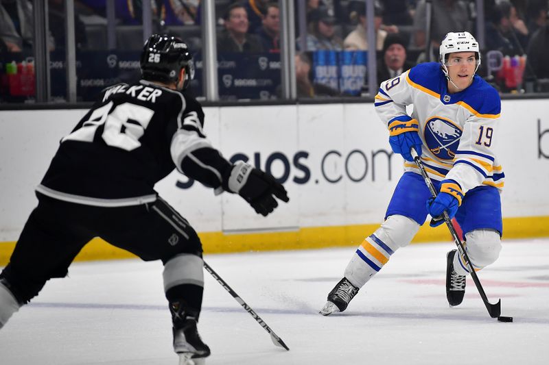 Feb 13, 2023; Los Angeles, California, USA; Buffalo Sabres center Peyton Krebs (19) moves the puck against Los Angeles Kings defenseman Sean Walker (26) during the first period at Crypto.com Arena. Mandatory Credit: Gary A. Vasquez-USA TODAY Sports