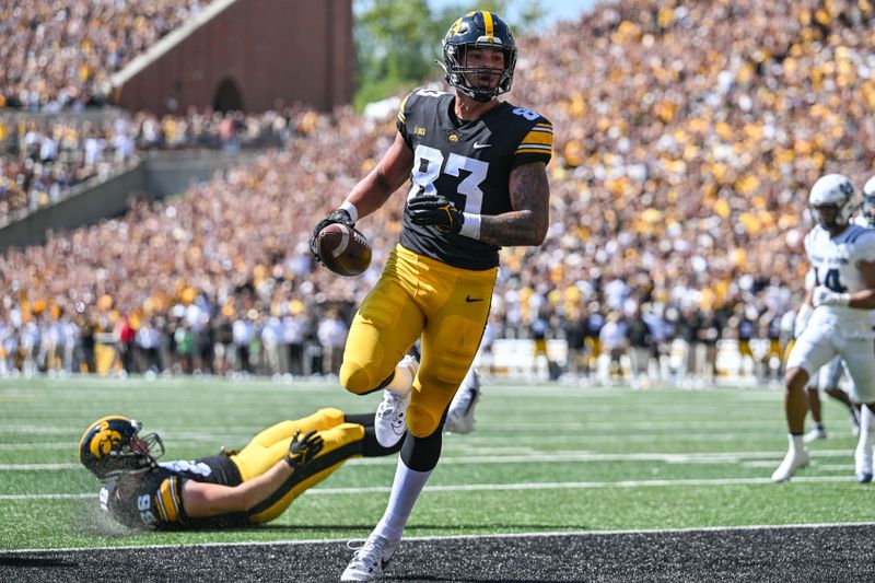 Sep 2, 2023; Iowa City, Iowa, USA; Iowa Hawkeyes tight end Erick All (83) scores on a touchdown pass as tight end Steven Stilianos (86) lay on the turf during the first quarter against the Utah State Aggies at Kinnick Stadium. Mandatory Credit: Jeffrey Becker-USA TODAY Sports