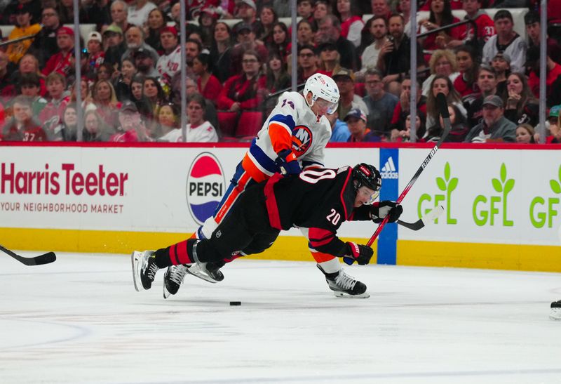 Apr 20, 2024; Raleigh, North Carolina, USA; New York Islanders center Bo Horvat (14) checks Carolina Hurricanes center Sebastian Aho (20) during the third period in game one of the first round of the 2024 Stanley Cup Playoffs at PNC Arena. Mandatory Credit: James Guillory-USA TODAY Sports