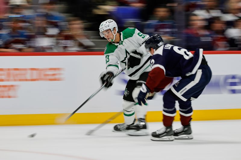 Oct 11, 2025; Denver, Colorado, USA; Dallas Stars center Wyatt Johnston (53) shoots the puck as Colorado Avalanche left wing Artturi Lehkonen (62) defends in the first period at Ball Arena. Mandatory Credit: Isaiah J. Downing-Imagn Images