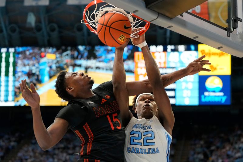 Mar 1, 2025; Chapel Hill, North Carolina, USA;  North Carolina Tar Heels forward Ven-Allen Lubin (22) scores as Miami (Fl) Hurricanes forward Kiree Huie (15) defends in the second half at Dean E. Smith Center. Mandatory Credit: Bob Donnan-Imagn Images