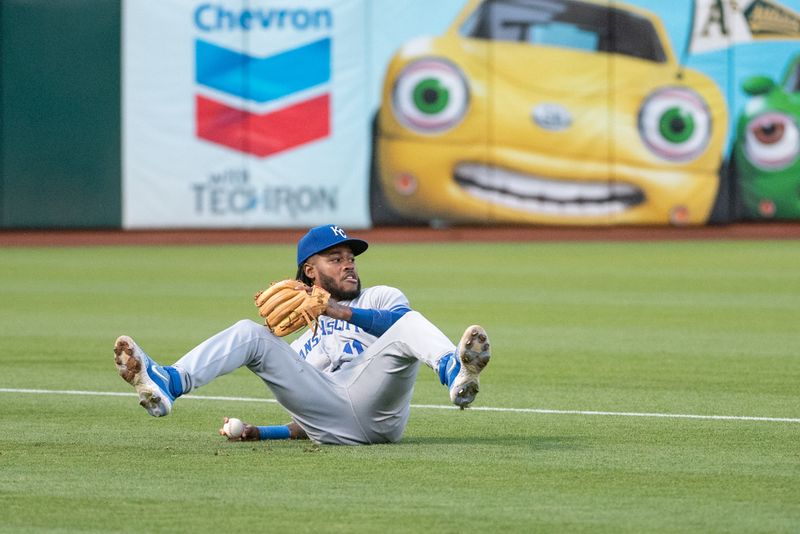 Aug 22, 2023; Oakland, California, USA; Kansas City Royals third baseman Maikel Garcia (11) throws the ball from the ground during the third inning against the Oakland Athletics at Oakland-Alameda County Coliseum. Mandatory Credit: Ed Szczepanski-USA TODAY Sports