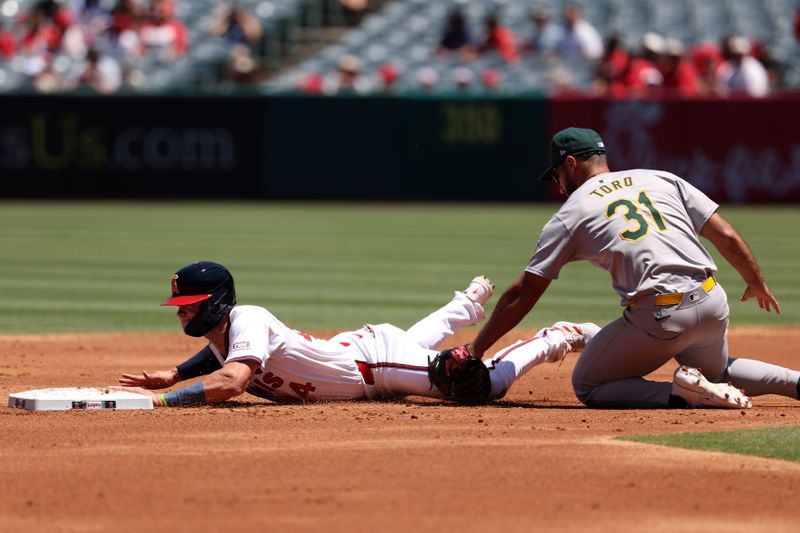 Jul 28, 2024; Anaheim, California, USA;  Los Angeles Angels catcher Logan O'Hoppe (14) is tagged out by Oakland Athletics second baseman Abraham Toro (31) on a caught stealing during the second inning at Angel Stadium. Mandatory Credit: Kiyoshi Mio-USA TODAY Sports