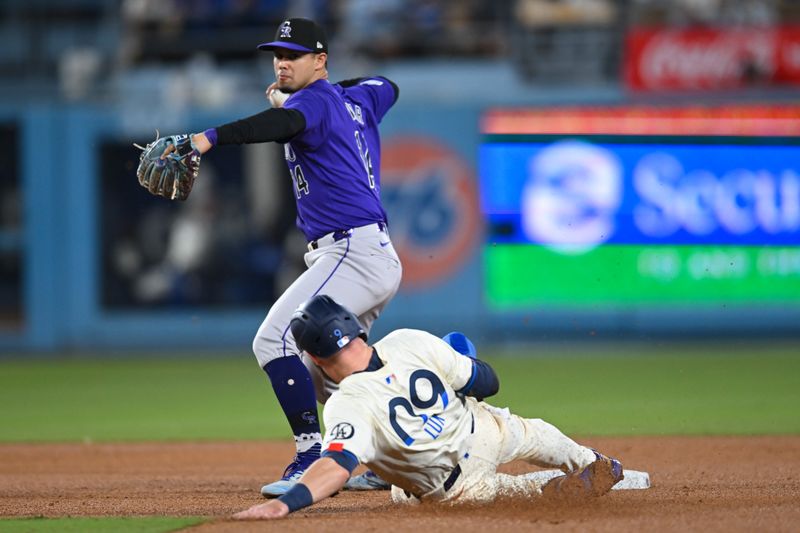 Sep 21, 2024; Los Angeles, California, USA; Colorado Rockies shortstop Ezequiel Tovar (14) forces out Los Angeles Dodgers second baseman Gavin Lux (9) and throws to first base for a double play during the eighth inning at Dodger Stadium. Mandatory Credit: Jonathan Hui-Imagn Images