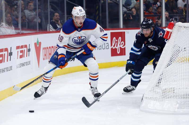 Sep 25, 2024; Winnipeg, Manitoba, CAN; Edmonton Oilers forwrad Noah Philp (48) skates away from Winnipeg Jets defenseman Dylan Samberg (54) during the first period at Canada Life Centre. Mandatory Credit: Terrence Lee-Imagn Images