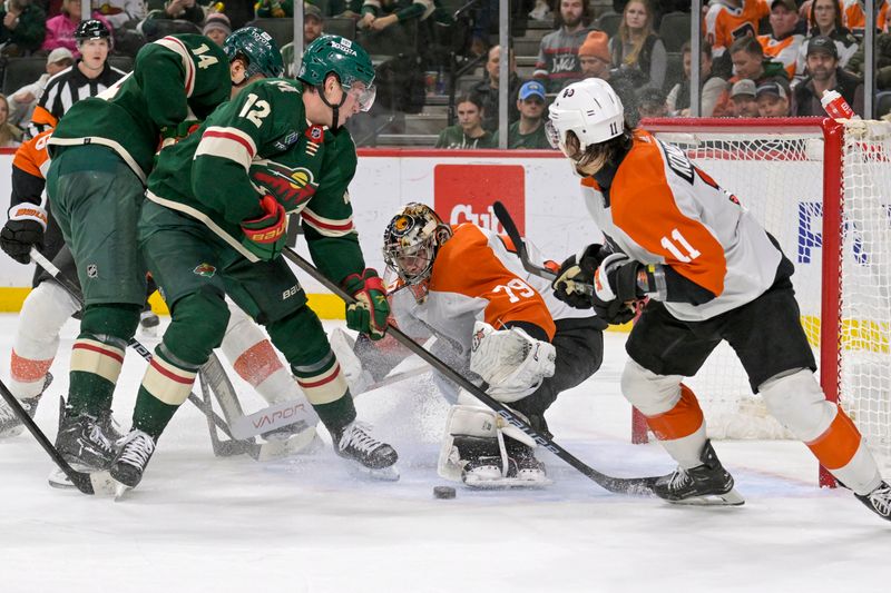 Jan 12, 2024; Saint Paul, Minnesota, USA; Philadelphia Flyers goalie Carter Hart (79) makes a save on Minnesota Wild forward Matt Boldy (12) during overtime at Xcel Energy Center. Mandatory Credit: Nick Wosika-USA TODAY Sports