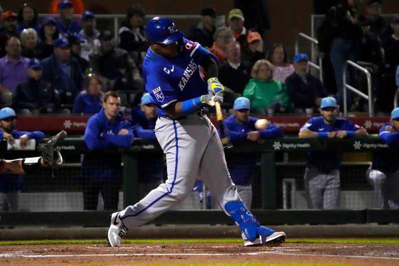 Mar 19, 2024; Scottsdale, Arizona, USA; Kansas City Royals catcher Salvador Perez (13) hits an RBI single against the San Francisco Giants in the first inning at Scottsdale Stadium. Mandatory Credit: Rick Scuteri-USA TODAY Sports