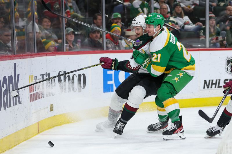 Jan 13, 2024; Saint Paul, Minnesota, USA; Arizona Coyotes defenseman Josh Brown (3) and Minnesota Wild right wing Brandon Duhaime (21) compete for the puck during the second period at Xcel Energy Center. Mandatory Credit: Matt Krohn-USA TODAY Sports