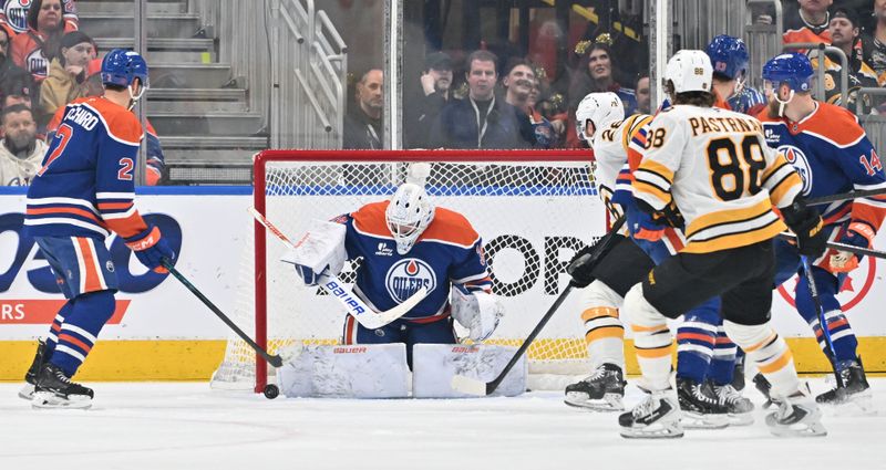 Dec 31, 2025; Edmonton, Alberta, CAN; Edmonton Oilers goalie Connor Ingram (39) looks for the puck as Boston Bruins center Elias Lindholm (28) and right winger David Pastrnak (88) look on during the first period at Rogers Place. Mandatory Credit: Walter Tychnowicz-Imagn Images