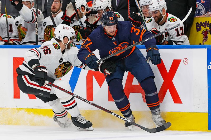 Jan 25, 2024; Edmonton, Alberta, CAN; Edmonton Oilers forward Warren Foegele (37) and Chicago Blackhawks defensemen Jarred Tinordi (25) battle along the boards for a loose puck during the third period at Rogers Place. Mandatory Credit: Perry Nelson-USA TODAY Sports