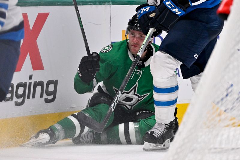 Apr 10, 2025; Dallas, Texas, USA; Dallas Stars right wing Mikko Rantanen (96) is taken down by Winnipeg Jets defenseman Dylan Samberg (54) during the second period at the American Airlines Center. Mandatory Credit: Jerome Miron-Imagn Images
