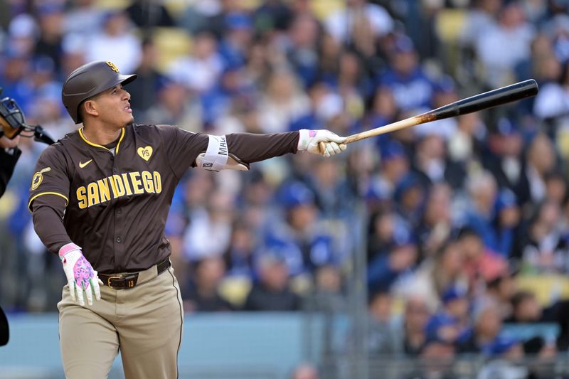 Apr 14, 2024; Los Angeles, California, USA; San Diego Padres third base Manny Machado (13) hits a solo home run in the fourth inning against the Los Angeles Dodgers at Dodger Stadium. Mandatory Credit: Jayne Kamin-Oncea-USA TODAY Sports