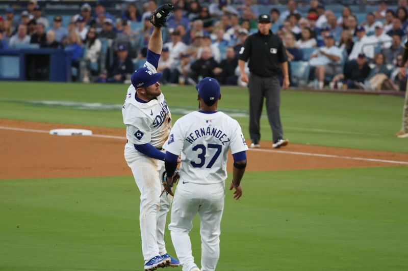 Oct 6, 2024; Los Angeles, California, USA; Los Angeles Dodgers third baseman Max Muncy (13) makes a catch in the fifth inning against the San Diego Padres during game two of the NLDS for the 2024 MLB Playoffs at Dodger Stadium. Mandatory Credit: Kiyoshi Mio-Imagn Images