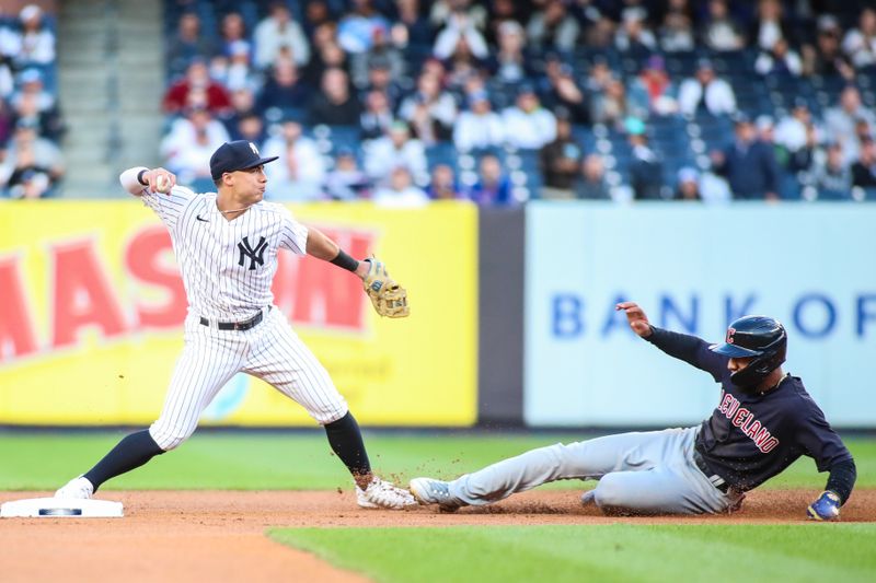 May 1, 2023; Bronx, New York, USA;  New York Yankees shortstop Anthony Volpe (11) throws past Cleveland Guardians shortstop Amed Rosario (1) attempting to complete a double play in the first inning at Yankee Stadium. Mandatory Credit: Wendell Cruz-USA TODAY Sports