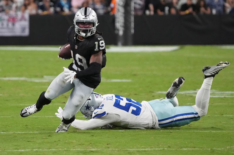 Las Vegas Raiders wide receiver DJ Turner (19) avoids a tackle by Dallas Cowboys linebacker Nick Vigil (52) during the second half of an NFL preseason football game, Saturday, Aug. 17, 2024, in Las Vegas. (AP Photo/Rick Scuteri)