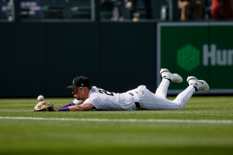 Apr 10, 2024; Denver, Colorado, USA; Colorado Rockies left fielder Nolan Jones (22) dives for a fly ball but is unable to make the catch in the ninth inning against the Arizona Diamondbacks at Coors Field. Mandatory Credit: Isaiah J. Downing-USA TODAY Sports