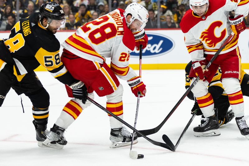 Oct 14, 2023; Pittsburgh, Pennsylvania, USA; Pittsburgh Penguins defenseman Kris Letang (58) traps the stick of Calgary Flames center Elias Lindholm (28) as he attempts to shoot the puck during the second period at PPG Paints Arena. Mandatory Credit: Scott Galvin-USA TODAY Sports