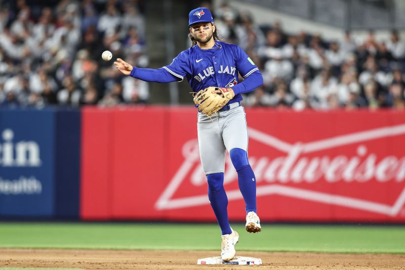 Apr 6, 2024; Bronx, New York, USA; Toronto Blue Jays shortstop Bo Bichette (11) throws to first base to complete a double play in the fifth inning against the New York Yankees at Yankee Stadium. Mandatory Credit: Wendell Cruz-USA TODAY Sports