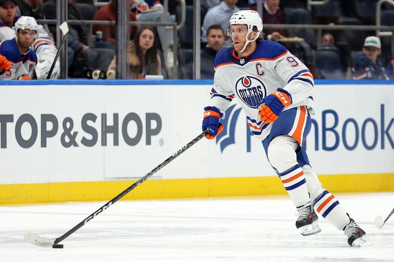 Dec 19, 2023; Elmont, New York, USA; Edmonton Oilers center Connor McDavid (97) brings the puck up ice against the New York Islanders during the first period at UBS Arena. Mandatory Credit: Brad Penner-USA TODAY Sports