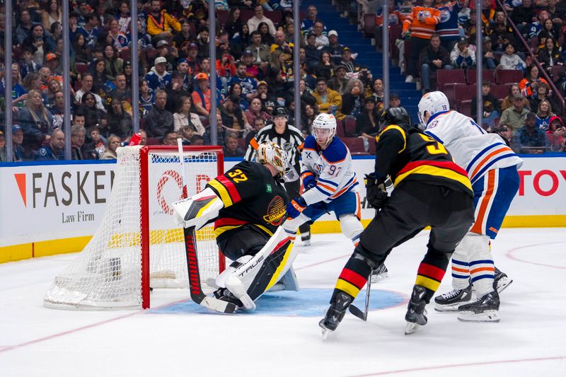 Nov 9, 2024; Vancouver, British Columbia, CAN; Edmonton Oilers forward Connor McDavid (97) scores against Vancouver Canucks defenseman Tyler Myers (57) and goalie Kevin Lankinen (32) during the third period at Rogers Arena. Mandatory Credit: Bob Frid-Imagn Images