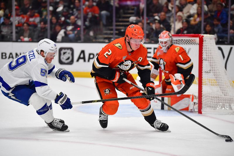 Dec 31, 2025; Anaheim, California, USA; Anaheim Ducks defenseman Jackson Lacombe (2) moves the puck against Tampa Bay Lightning center Jake Guentzel (59) during the first period at Honda Center. Mandatory Credit: Gary A. Vasquez-Imagn Images