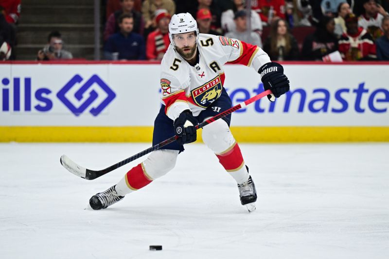 Nov 21, 2024; Chicago, Illinois, USA; Florida Panthers defenseman Aaron Ekblad (5) passes the puck against the Chicago Blackhawks during the first period at the United Center. Mandatory Credit: Daniel Bartel-Imagn Images