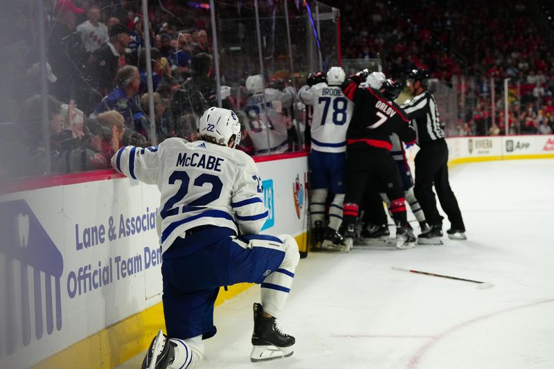 Mar 24, 2024; Raleigh, North Carolina, USA;  Toronto Maple Leafs defenseman Jake McCabe (22) kneels after being bordered on the play against the Carolina Hurricanes during the first period at PNC Arena. Mandatory Credit: James Guillory-USA TODAY Sports