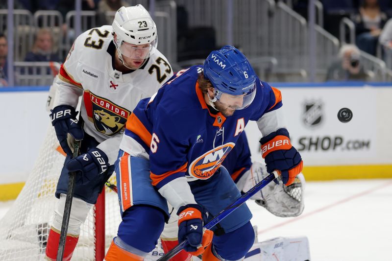 Mar 28, 2026; Elmont, New York, USA; Florida Panthers center Carter Verhaeghe (23) fights for the puck against New York Islanders defenseman Ryan Pulock (6) during the third period at UBS Arena. Mandatory Credit: Brad Penner-Imagn Images