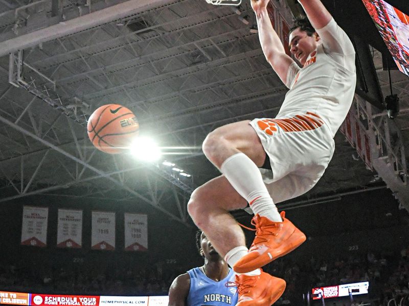 Jan 6, 2024; Clemson, South Carolina, USA;  Clemson junior forward Ian Schieffelin (4) dunks near University of North Carolina forward Harrison Ingram (55) during the second half at Littlejohn Coliseum. Mandatory Credit: Ken Ruinard-USA TODAY Sports