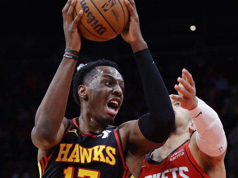 HOUSTON, TEXAS - DECEMBER 20: Onyeka Okongwu #17 of the Atlanta Hawks drives ahead of Dillon Brooks #9 of the Houston Rockets during the first half at Toyota Center on December 20, 2023 in Houston, Texas. User expressly acknowledges and agrees that, by downloading and or using this photograph, User is consenting to the terms and conditions of the Getty Images License Agreement.?  (Photo by Carmen Mandato/Getty Images)