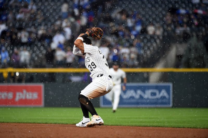 Jun 25, 2025; Denver, Colorado, USA; Colorado Rockies second base Thairo Estrada (39) loses the ball in the rain for a two RBI infield single during the sixth inning against the Los Angeles Dodgers at Coors Field. Mandatory Credit: Christopher Hanewinckel-Imagn Images