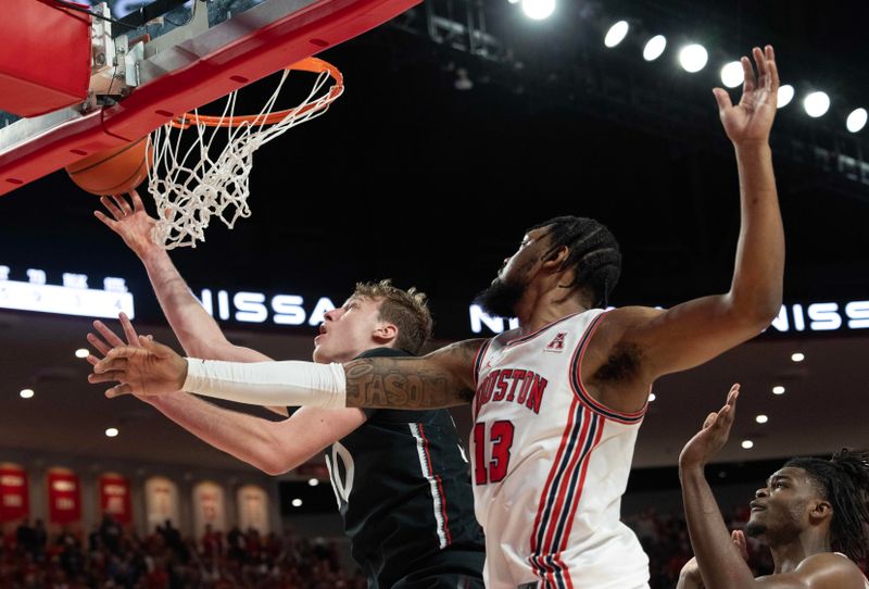 Jan 28, 2023; Houston, Texas, USA; Cincinnati Bearcats forward Viktor Lakhin (30) shoots against Houston Cougars forward J'Wan Roberts (13) in the second half at Fertitta Center. Cincinnati Bearcats forward Viktor Lakhin (30) was called for goaltending. Houston Cougars won 75 to 69 .Mandatory Credit: Thomas Shea-USA TODAY Sports