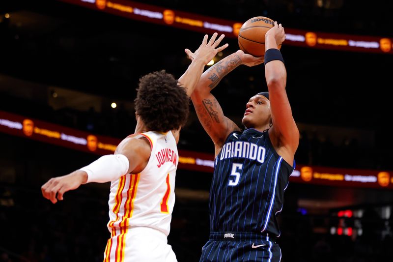 ATLANTA, GEORGIA - JANUARY 17: Paolo Banchero #5 of the Orlando Magic shoots against Jalen Johnson #1 of the Atlanta Hawks during the first quarter at State Farm Arena on January 17, 2024 in Atlanta, Georgia. NOTE TO USER: User expressly acknowledges and agrees that, by downloading and or using this photograph, User is consenting to the terms and conditions of the Getty Images License Agreement. (Photo by Todd Kirkland/Getty Images)