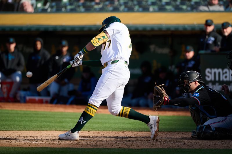 May 4, 2024; Oakland, California, USA; Oakland Athletics infielder Brett Harris (77) hits a one-run home run against the Miami Marlins for his first MLB career hit during the fourth inning at Oakland-Alameda County Coliseum. Mandatory Credit: Robert Edwards-USA TODAY Sports
