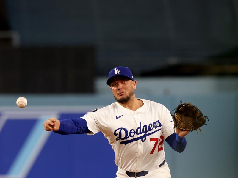 May 14, 2025; Los Angeles, California, USA; Los Angeles Dodgers hitting coach Robert Van Scoyoc (72) throws to first for an out during the ninth inning against the Athletics at Dodger Stadium. Mandatory Credit: Jason Parkhurst-Imagn Images