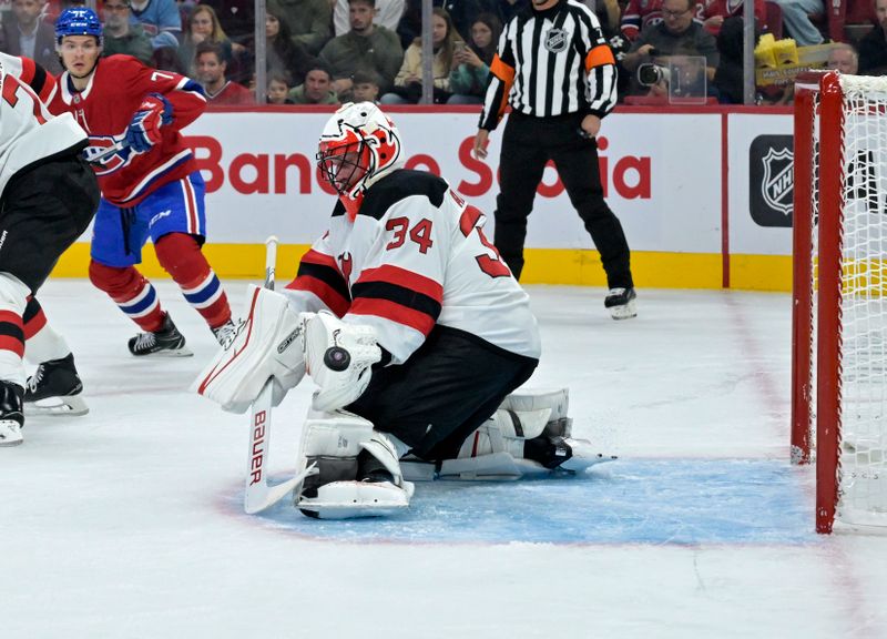 Sep 24, 2024; Montreal, Quebec, CAN; New Jersey Devils goalie Jake Allen (34) makes a save during the first period of the game against the Montreal Canadiens at the Bell Centre. Mandatory Credit: Eric Bolte-Imagn Images