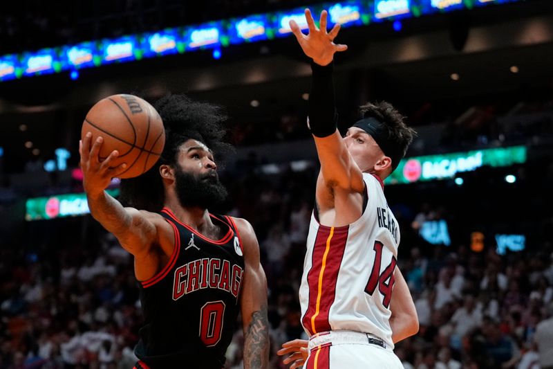 MIAMI, FLORIDA - APRIL 19: Coby White #0 of the Chicago Bulls goes up for a shot against Tyler Herro #14 of the Miami Heat in the third quarter during the Play-In Tournament at Kaseya Center on April 19, 2024 in Miami, Florida. NOTE TO USER: User expressly acknowledges and agrees that, by downloading and or using this photograph, User is consenting to the terms and conditions of the Getty Images License Agreement. (Photo by Rich Storry/Getty Images)