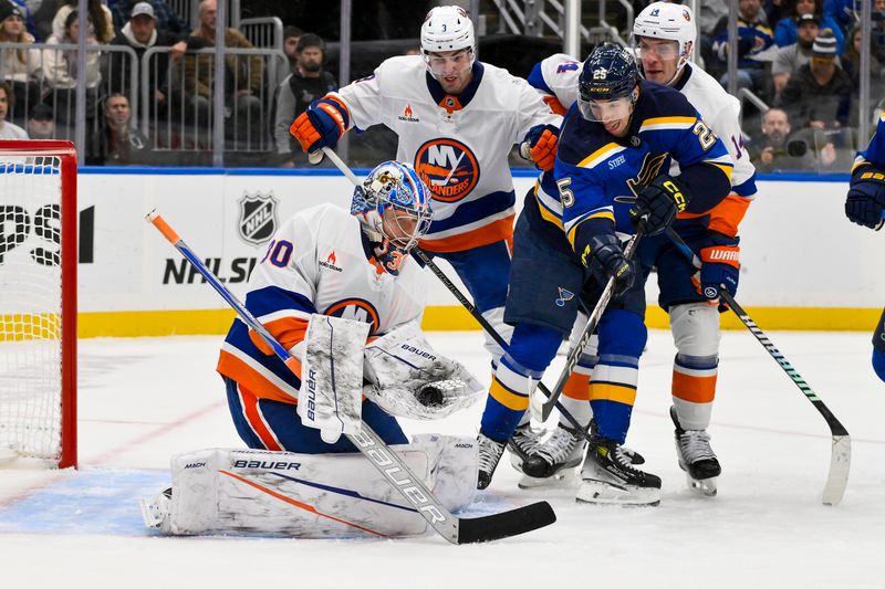 Oct 17, 2024; St. Louis, Missouri, USA;  New York Islanders goaltender Ilya Sorokin (30) makes a glove save as defenseman Adam Pelech (3) defends against St. Louis Blues center Jordan Kyrou (25) during the second period at Enterprise Center. Mandatory Credit: Jeff Curry-Imagn Images