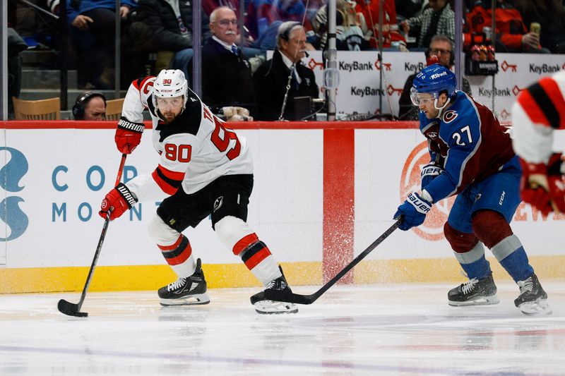 Feb 26, 2025; Denver, Colorado, USA; New Jersey Devils left wing Tomas Tatar (90) controls the puck as Colorado Avalanche left wing Jonathan Drouin (27) defends in the second period at Ball Arena. Mandatory Credit: Isaiah J. Downing-Imagn Images