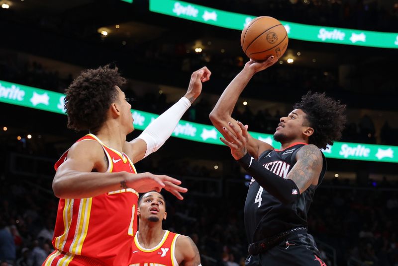 ATLANTA, GEORGIA - FEBRUARY 10:  Jalen Green #4 of the Houston Rockets drives against Dejounte Murray #5 and Jalen Johnson #1 of the Atlanta Hawks during the fourth quarter at State Farm Arena on February 10, 2024 in Atlanta, Georgia.  NOTE TO USER: User expressly acknowledges and agrees that, by downloading and/or using this photograph, user is consenting to the terms and conditions of the Getty Images License Agreement.  (Photo by Kevin C. Cox/Getty Images)